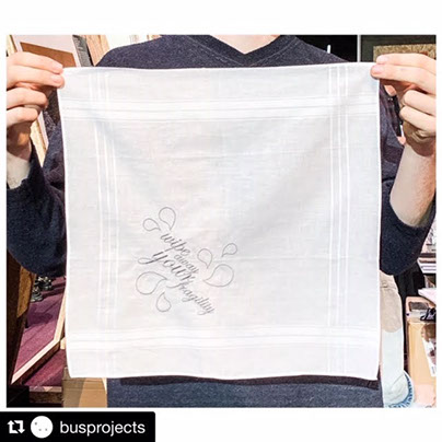 Wipe Away Your Fragility Person holding white hankerchief that shows embroidered text reading "wipe away your fragility"